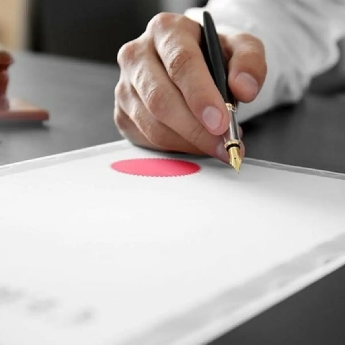 Hand signing and stamping an official document with a red certification seal